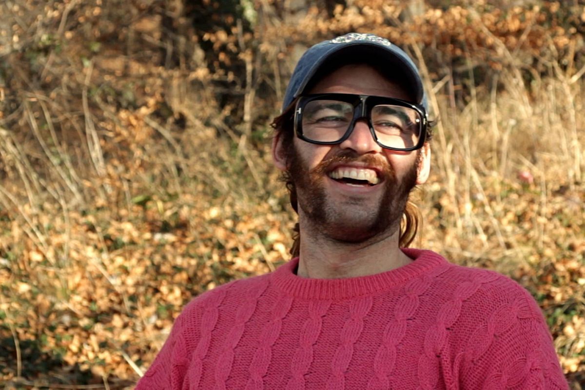 Portrait of a smiling young man, autumn leaves on the background.