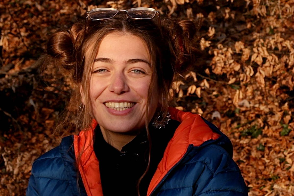 Portrait of a smiling young woman, autumn leaves on the background.