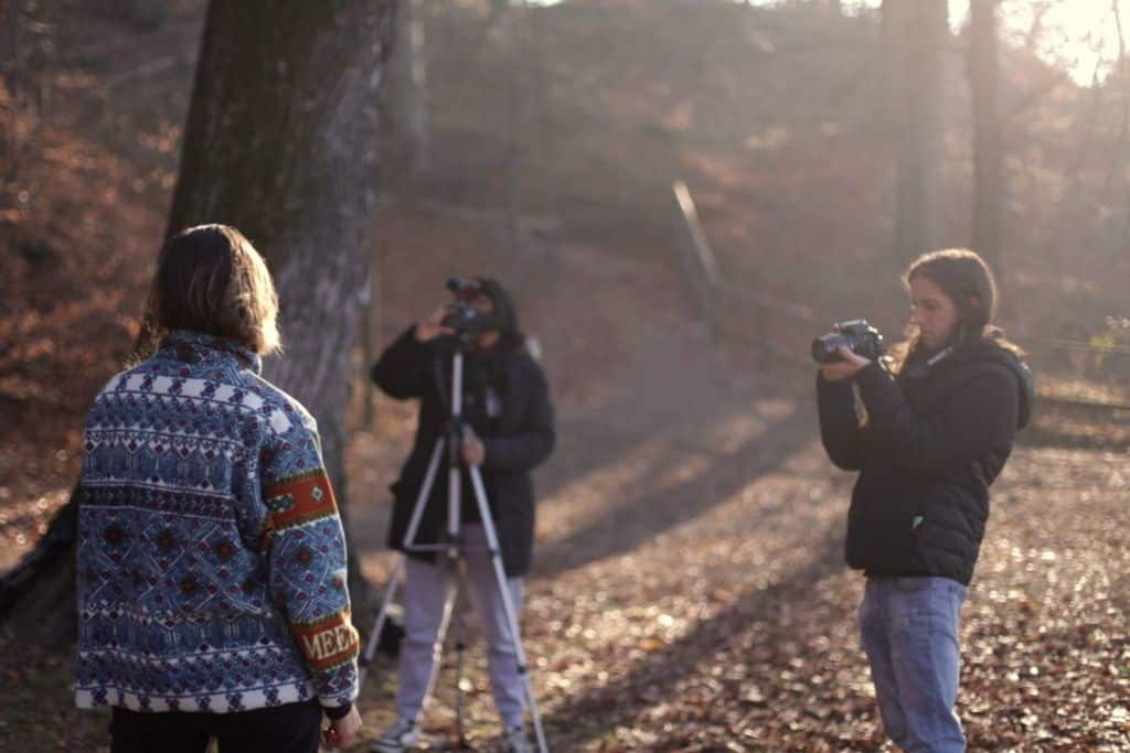 Three people filming an interview in the woods