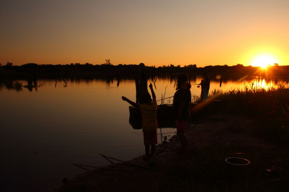 People fishing on Iguaçu lake at sunset