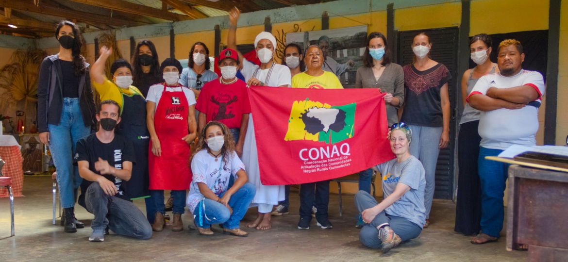 A group of people holding the flag of CONAQ