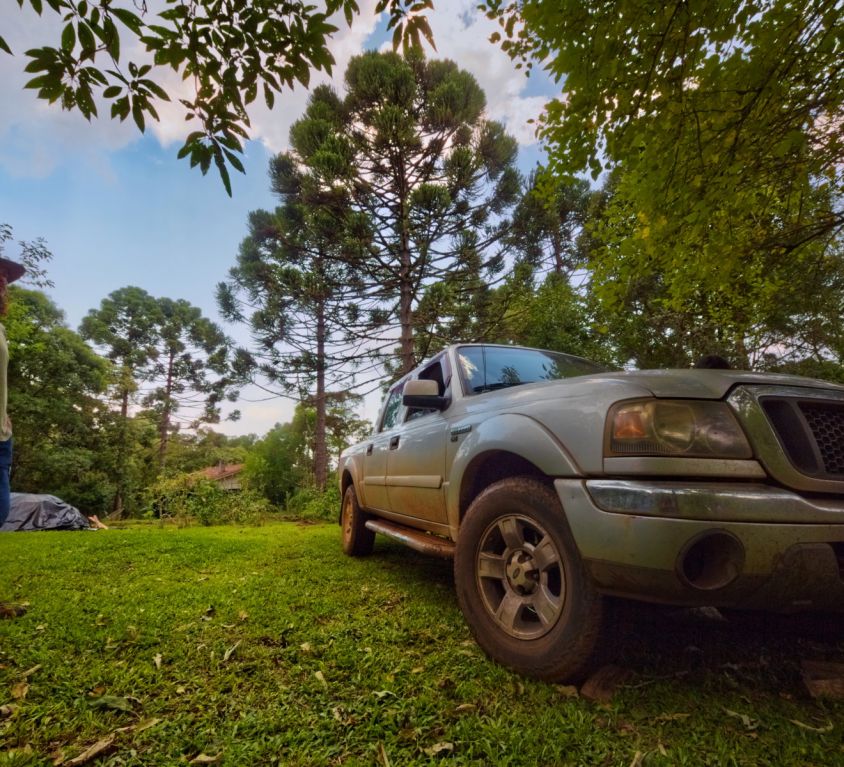A man in front of a pickup in a campsite
